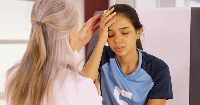 A young soccer player with a head injury receives medical attention