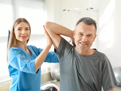 Physiotherapist working with mature patient in rehabilitation center