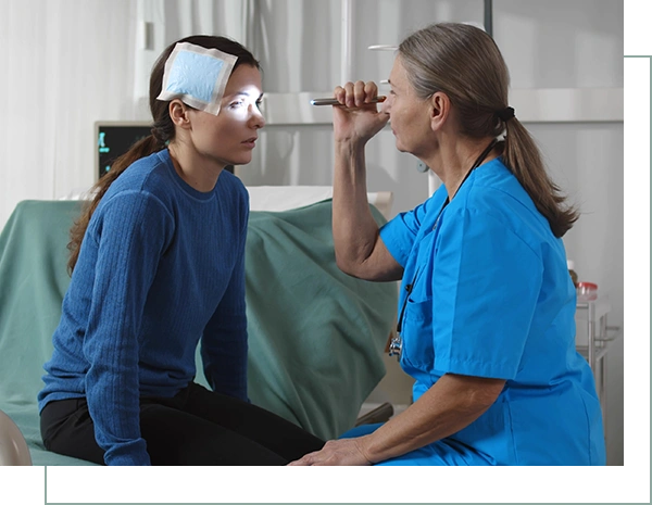 Injured woman sitting on hospital bed with nurse woman shining in her eyes with flashlight
