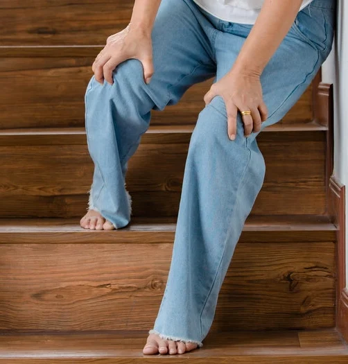 Woman stops for rest and leaning on wall for support while she cannot climb stairs with tingling legs