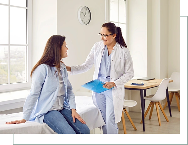 Happy young pregnant woman talking with her gynecologist doctor