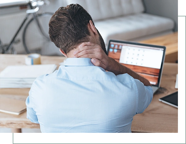 Rear view of frustrated young man looking exhausted and massaging his neck
