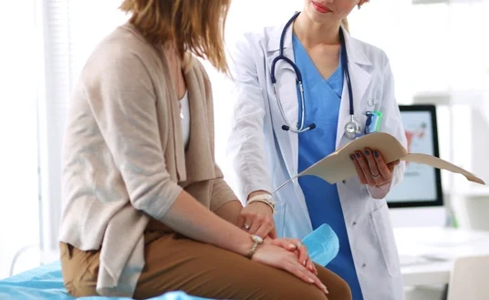 Doctor and patient discussing something while sitting at the table