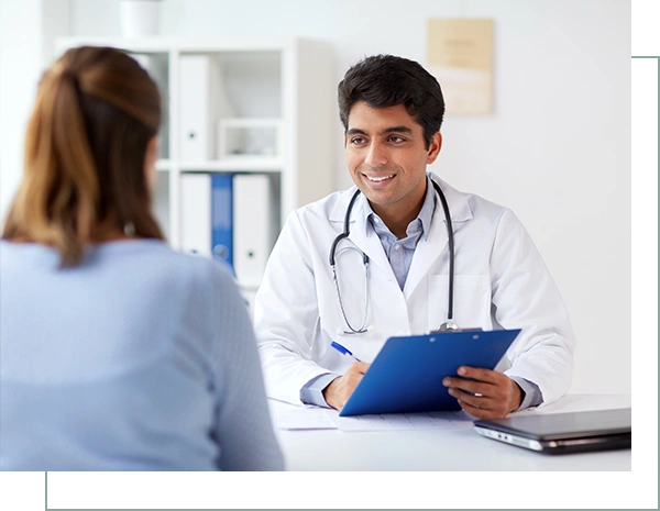 smiling doctor with clipboard and patient at hospital